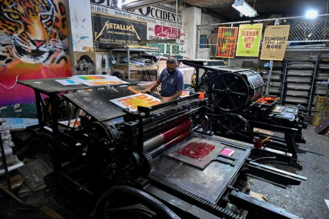 Jaime Garcia imprime des affiches sur la machine française Marinoni de 1870 à l'imprimerie La Linterna, le 4 mars 2021 à Cali, en Colombie