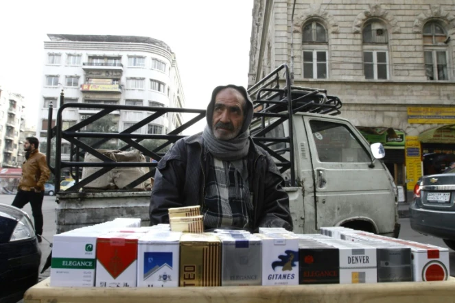 Le Syrien Abou Zyad vend des cigarettes devant son pick-up à Damas, le 17 décembre 2015