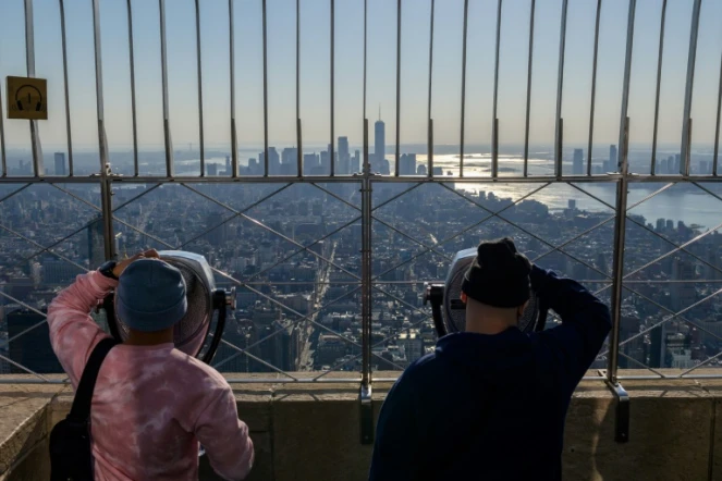 Des visiteurs admirent la vue depuis le 86ème étage de l'Empire State Building à New York, le 9 novembre 2021, au lendemain de la réouverture des frontières américaines aux voyageurs européens notamment