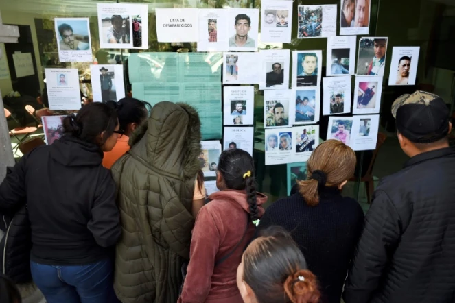 Des personnes cherchent les noms de leurs proches sur la liste des disparus dans l'explosion d'un oléoduc perforé par des voleurs de carburants, à Tlahuelilpan, dans le centre du Mexique, le 20 janvier 2019