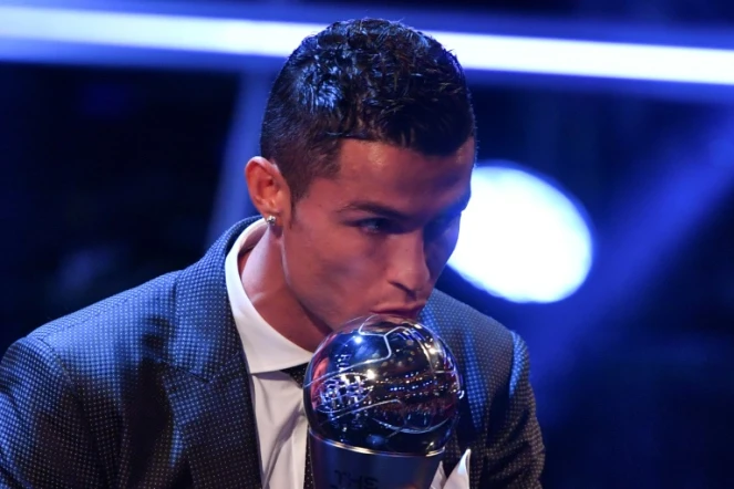 L'attaquant du Real Madrid et du Portugal Cristiano Ronaldo embrasse le trophée après avoir reçu le prix du meilleur joueur Fifa de l'année, le 23 octobre 2017 à Londres