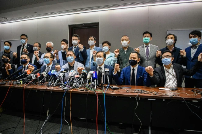 Des élus pro-démocratie de Hong Kong affichent leur solidarité en se tenant les mains avant une conférence de presse à Hong Kong, le 11 novembre 2020 pour annoncer leur démission
