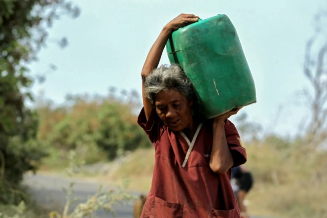 Virginia Lozano vit sans eau depuis neuf ans à Tonala, dans l'Etat de Jalisco. Comme chaque jour, elle  s'approvisionne en eau avec un bidon qu'elle porte sur ses épaules. Photo prise le 14 mars 2020. 