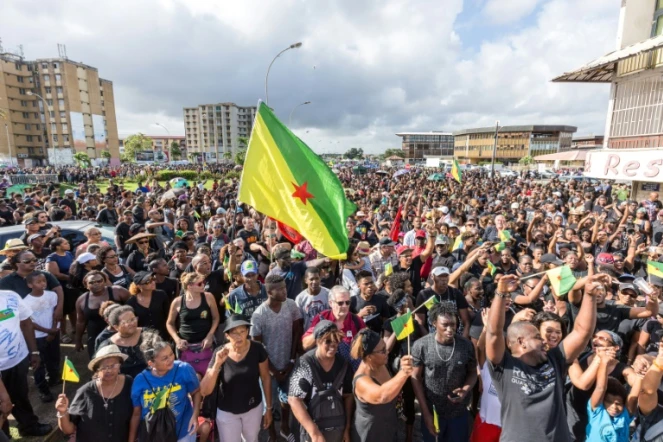 Mes manifestants agitent le drapeau de la Guyane lors d'un rassemblement en soutien à la grève générale, à Cayenne le 28 mars 2017