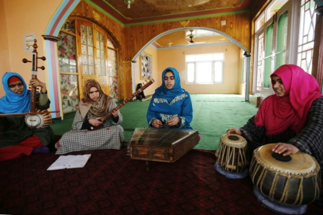 Des jeunes femmes soufies jouent de la musique traditionnelle sous l'oeil de leur professeur, le 25 février 2017 à Srinagar, au Cachemire indien