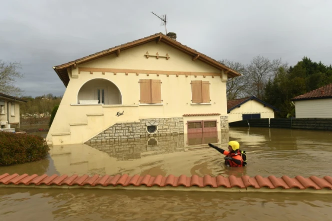 Un pompier passe dans une zone complètement inondée de Peyrehorade, le 14 décembre 2019 dans les Landes