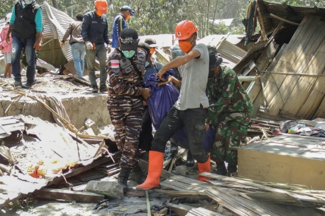 Des secouristes transportent des sacs mortuaires contenant des personnes décédées dans le village de Klatanlo sur l'île de Florès, en Indonésie, le 4 novembre 2024, après l'éruption du volcan Lewotobi Laki-Laki