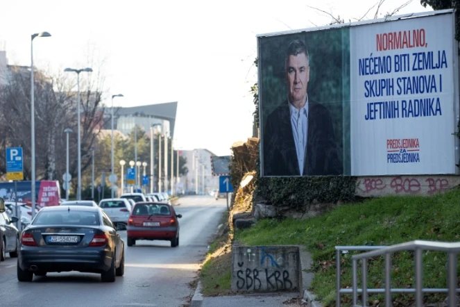 Une voiture passe devant une affiche électorale du président croate sortant et candidat à la présidentielle du Parti social-démocrate (SDP), Zoran Milanovic, dans le centre de Zagreb, le 27 décembre 2024