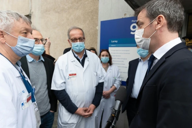 Le ministre français de la Santé et des Affaires sociales Olivier Véran (d) discute avec des employés de l'hôpital Avicenne à Bobigny (Seine-Saint-Denis), le 29 janvier 2021