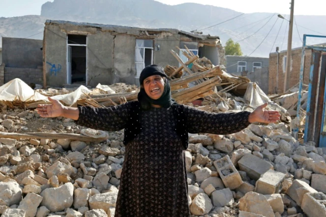 Photo prise le 15 novembre 2017 d'une Iranienne près des décombres de sa maison à Kouik (nord-ouest) après le séisme du 12 novembre
