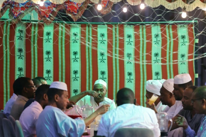 Des Soudanais bloqués, en Arabie saoudite, se retrouvent pour l'iftar collectif, le repas de rupture de jeûne du ramadan, le 27 mars 2024 à Ryad 