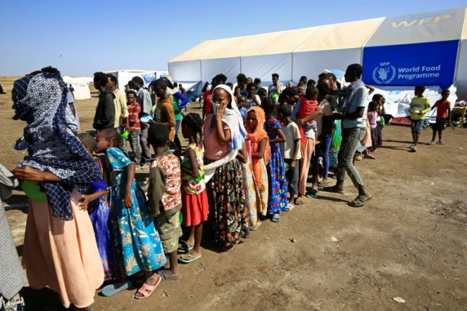 Des Ethiopiens, qui ont fui les combats dans la région du Tigré, attendent une distribution de nourriture, le 27 novembre 2020 dans un camp de réfugiés à Hamdayti, au Soudan