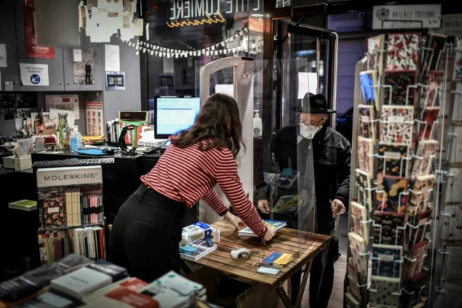 Un client vient retirer les livres commandés par internet dans une librairie parisienne le 31 octobre 2020. Le "click and collect" est autorisé lors de ce confinement. 
