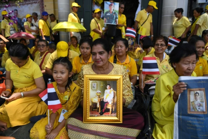 Des Thaïlandaises tiennent le portrait du roi Maha Vajiralongkorn, près du Grand palais, en attendant la grande parade pour son couronnement dans les rues de Bangkok, le 5 mai 2019