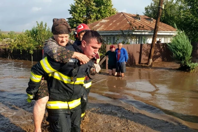 Un secouriste évacue une femme âgée, le 14 septembre 2024, dans le village inondé de Pechea, en Roumanie