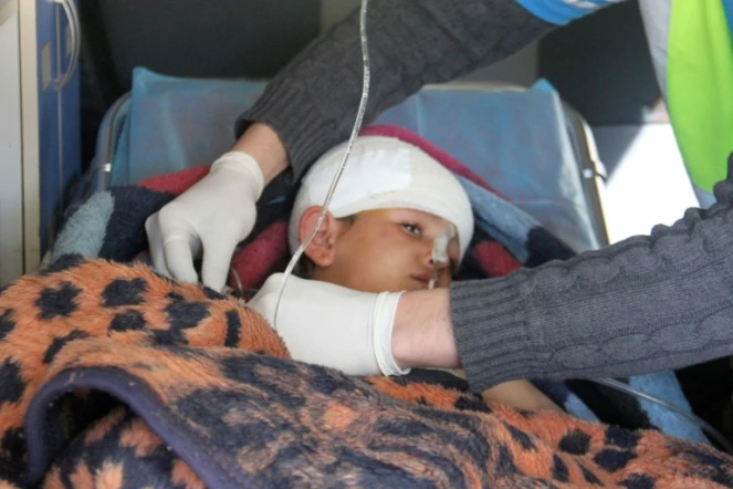 Un enfant syrien, Abdel Basset Al-Satuf (C) dans une ambulance à Al-Hbeit, dans la province d'Idleb le 17 février 2017 
