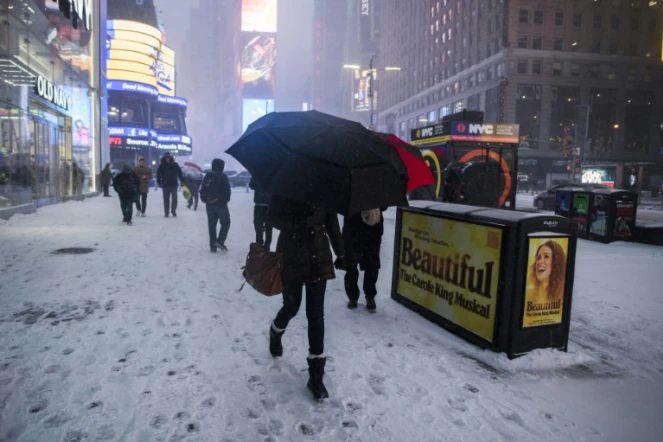 Des passants sur Times Square enneigé à Manhattan le 4 janvier 2018
