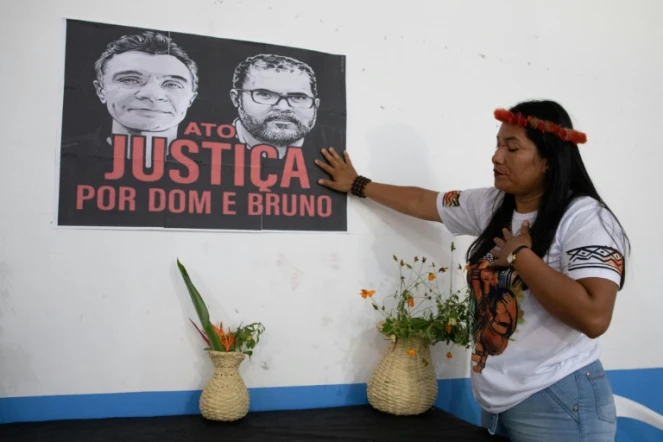 Une femme indigène touche une affiche réclamant justice pour l'expert indigène Bruno Pereira et le journaliste britannique Dom Phillips lors d'une cérémonie pour leur mort au siège de l'association de l'Union des peuples indigènes de la vallée de Javari (UNIVAJA), à Atalaia do Norte, dans l'État d'Amazonas, au Brésil, le 21 juin 2022