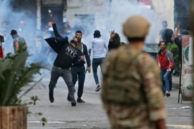 Des manifestants lancent des pierres sur l'armée à Tripoli, dans le nord du Liban, le 28 avril 2020 