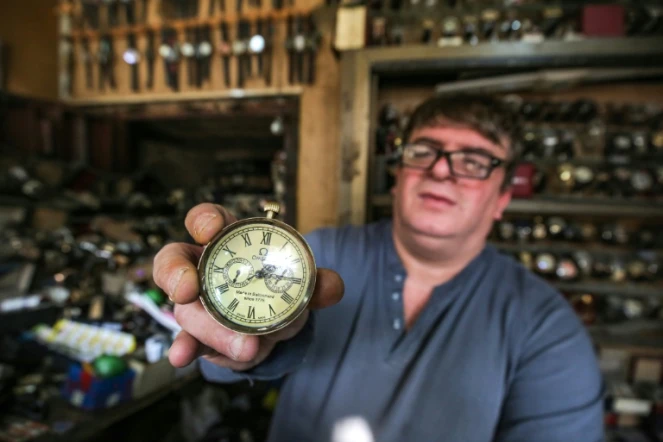 Youssef Abdelkarim, réparateur de montres, présente un modèle Omega dans son magasin de la rue Rachid, à Bagdad, le 9 décembre 2020
