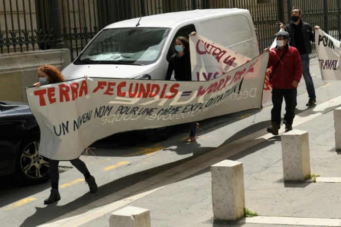 Des manifestants brandissent une banderole devant le tribunal de Marseille au premier jour du procès Terra Fecundis, le 17 mai 2021