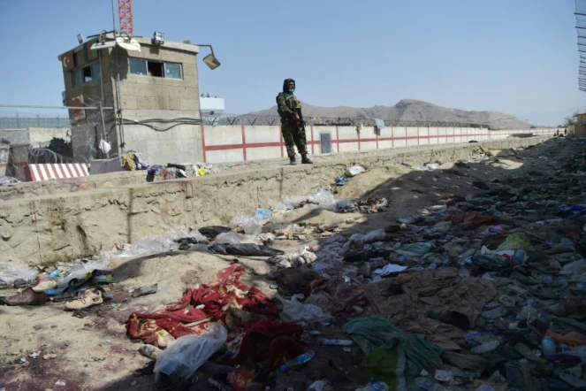 Un combattant taliban se tient face au site d'un attentat à la bombe à l'aéroport de Kaboul le 27 août 2021