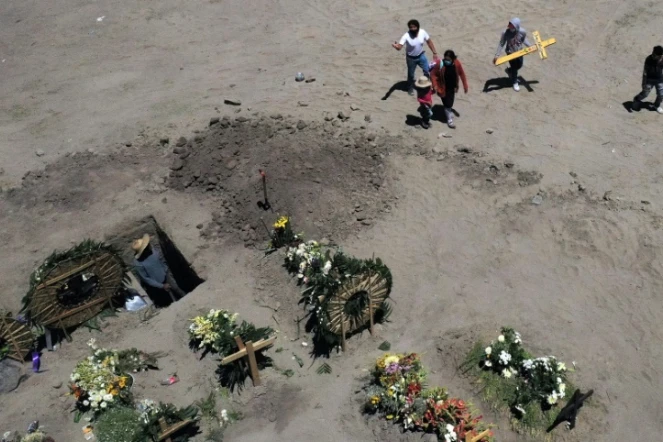 Les proches d'une victime du Covid-19 portent une croix, dans un cimetière de Valle de Chalco (Mexique), le 4 juin 2020