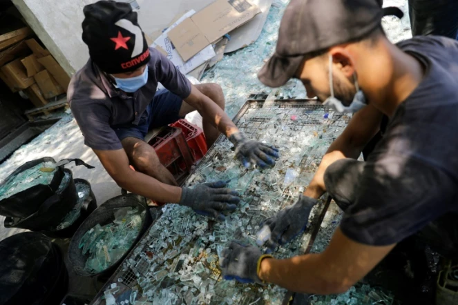 des ouvriers trient le verre cassé lors de l'explosion au port de Beyrouth pour le recycler à Tripoli, la ville portuaire du nord du Liban le 25 août 2020