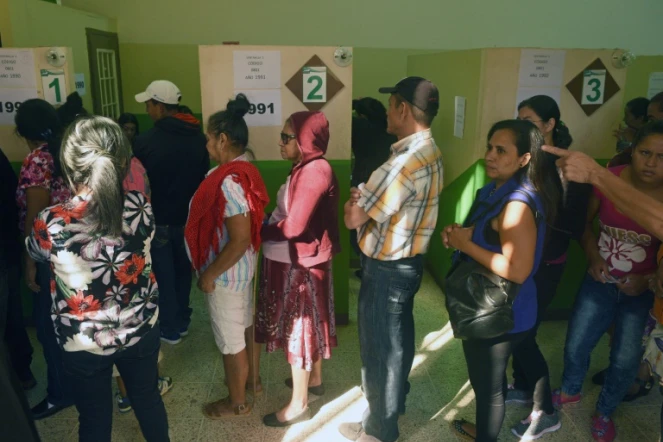 Des Honduriens attendent de recevoir leur carte d'électeur pour voter à la présidentielle, le 25 novembre 2017 à Tegucigalpa