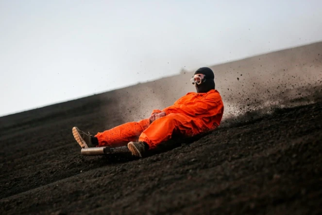 Un touriste descend sur une planche la pente du volcan Cerro Negro, le 22 mars 2022 au Nicaragua