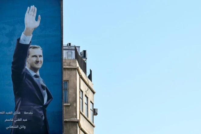Une affiche géante du président syrien Bachar al-Assad dans une rue de Damas, le 2 décembre 2024
