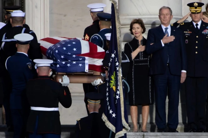 L'ancien président américain George W. Bush et son épouse Laura se recueille à l'arrivée du cercueil de George H. W. Bush au Capitole, le 3 décembre 2018