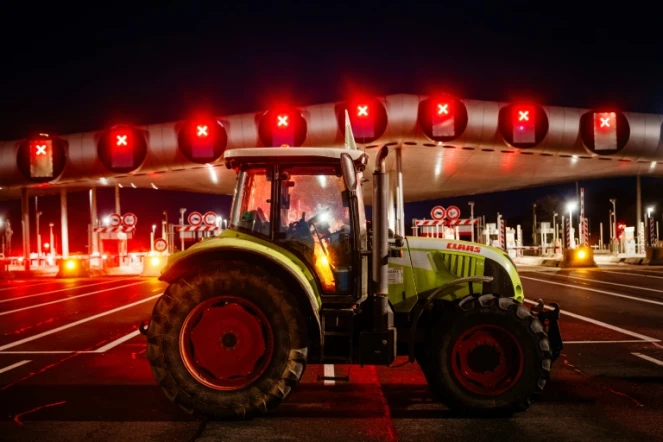 Des agriculteurs bloquent l'autoroute A10 avec des tracteurs, près des barrières de péage du Péage de Saint-Arnoult-en-Yvelines au sud-ouest de Paris, le 26 janvier 2024