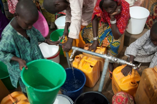 Des femmes et des enfants du camp de déplacés de Muna, à la périphérie de la grande ville de Maiduguri, capitale de l?État du Borno, au Nigeria, collectent de l'eau d'un puits le 30 juin 2016
