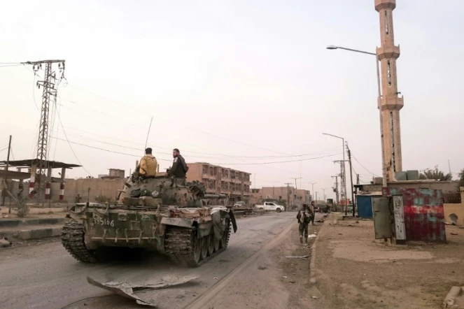 Des forces prorégime à bord d'un char dans une rue de la ville syrienne de Boukamal, le 20 novembre 2017 après sa reprise aux combattants jihadistes