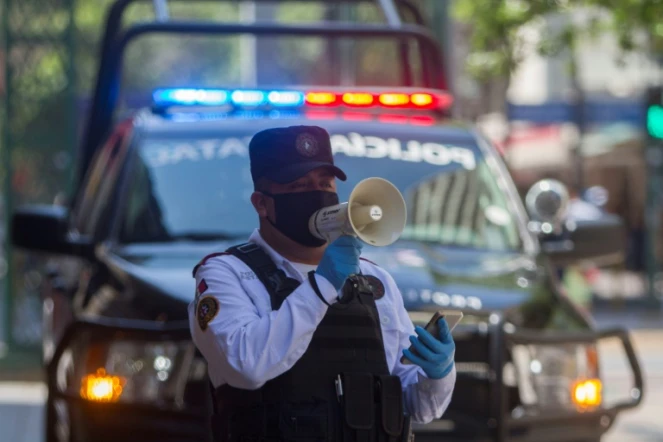 Un policier utilise un haut-parleur pour inviter les passants à rentrer chez eux, le 25 mars 2020 à Monterrey, au Mexique