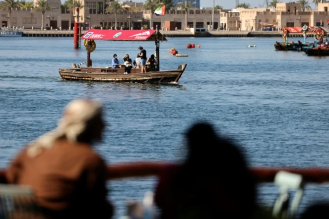 Des Emiratis regardent des bateaux transportant des touristes près du vieux quartier de Dubaï, aux Emirats arabe unis, le 6 janvier 2021