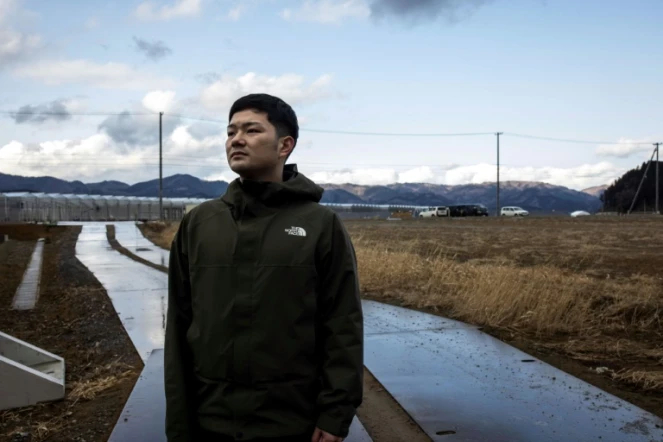 Yuto Naganuma, 26 ans, devant l'école primaire où son petit frère a perdu la vie pendant le tsunami de 2011, le 7 février 2021 à Ishinomaki, au Japon