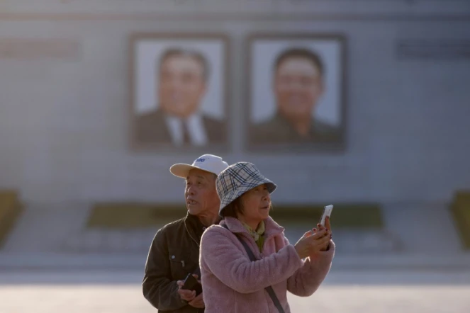 Des touristes chinois prennent des photos sur la place Kim Il Sung à Pyongyang, le 14 avril 2019 en Corée du Nord