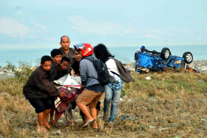 Un corps porté le 29 septembre 2018 par des habitants de Palu après un fort séisme sur l'île indonésienne des Célèbes.