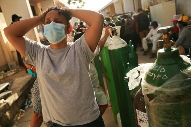 Des proches de malades du Covid-19 font la queue pour faire recharger des bouteilles d'oxygène à l'hôpital d'Iquitos, au Pérou, le 14 mai 2020
