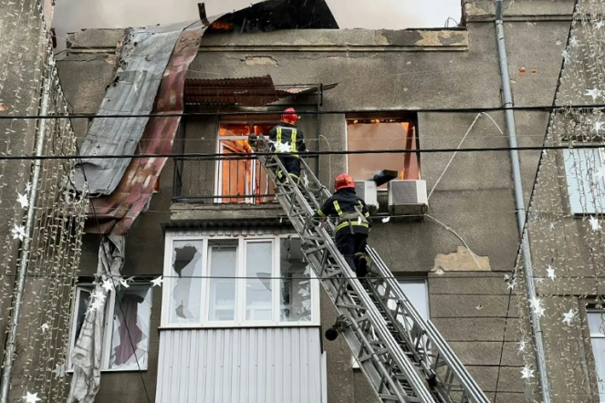 Des pompiers tentent d'éteindre un incendie dans un immeuble d'habitation après des frappes dans le centre de la ville ukrainienne de Kharkiv, le 17 avril 2022 