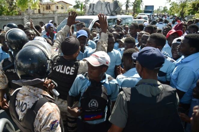 Des policiers haîtiens tentent de calmer des lycéens qui manifestent contre l'occupation de leur lycée Jean-Claudy Museau par des sinistrés de l'ouragan Matthew, le 16 novembre 2016 aux Cayes