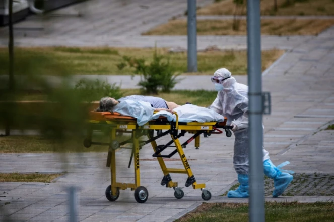 Un soignant transporte une malade du Covid-19 dans un hôpital à l'extérieur de Moscou, le 30 juin 2021