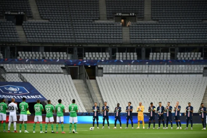 Les joueurs du Paris Saint-Germain et de Saint-Etienne durant la minute d'applaudissements en mémoire des victimes du Covid-19 avant la finale de la Coupe de France de football dans un stade avec peu de spectateurs le 24 juillet 2020 à Saint-Denis