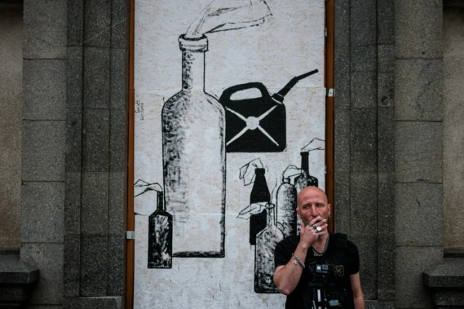 Le street artiste ukrainien Galmet Zinkovski devant son oeuvre à Kharkiv, dans l'est de l'Ukraine, le 16 mai 2022