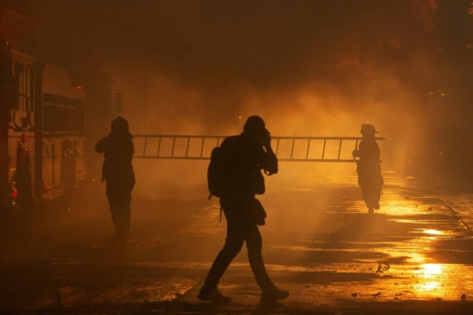 Des pompiers luttent contre un incendie après une manifestation antigouvernementale à Santiago (Chili) le 28 octobre 2019

