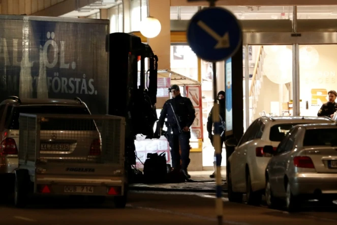 Des policiers surveillent, le 8 avril 2017, le camion volé utilisé la veille pour foncer sur la foule dans une rue commerçante de Stockholm, tuant cinq personnes