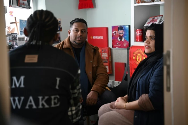 Uzma Naveed, coordinatrice, et Jeffrey Andrews, travailleur social, parlent à "John" dans un bureau de Centre d'action chrétien pour les réfugiés à Hong Kong