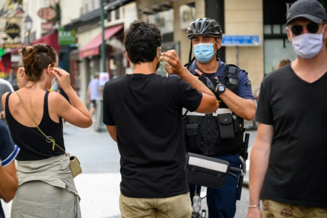 Un policier municipal demande à des passants de porter un masque de protection, le 15 août 2020 à Paris 